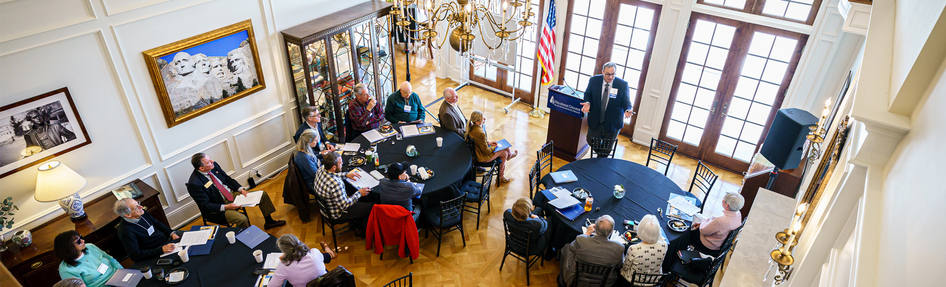 Seminar participants listen intently to a speaker at a podium.