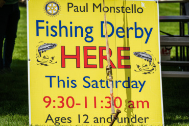 A yellow sign that says Fishing Derby HERE.