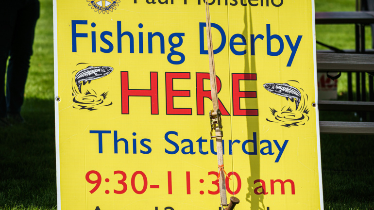 A yellow sign that says Fishing Derby HERE.